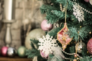 Ein Ausschnitt eines künstlichen Weihnachtsbäums geschmückt mit tollen Ornamenten.